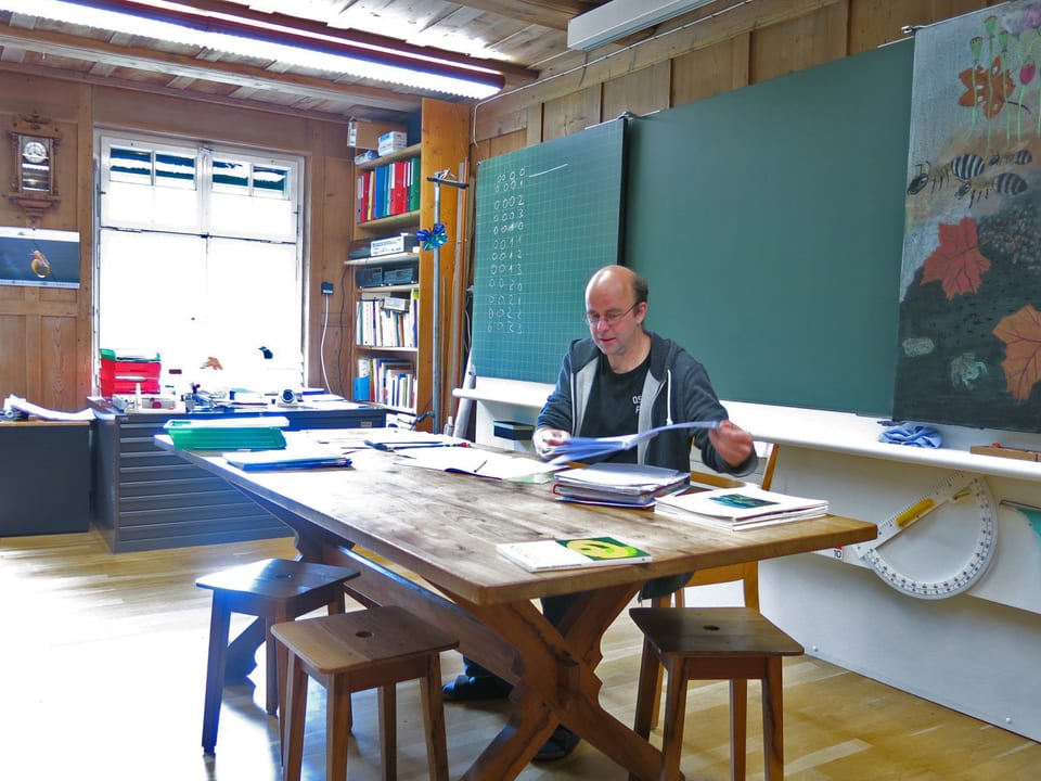 André Schibli sitzt am Lehrerpult.