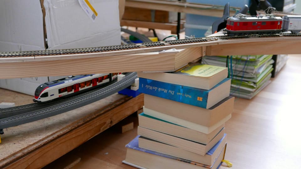 Ein Gleis, aufgebockt auf einem Stapel Bücher.