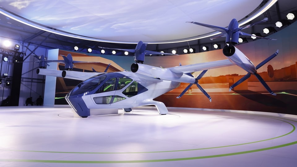 Eine Art Science-fiction-Flugzeug mit sechs Rotoren à je 4 Rotorenblätter, das mehr wie ein Helikopter aussieht.