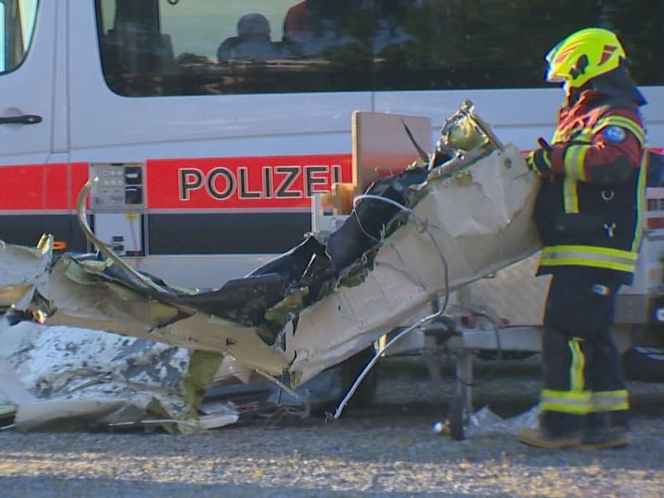 Rettungskräfte mit Trümmern des abgestürzten Flugzeugs.