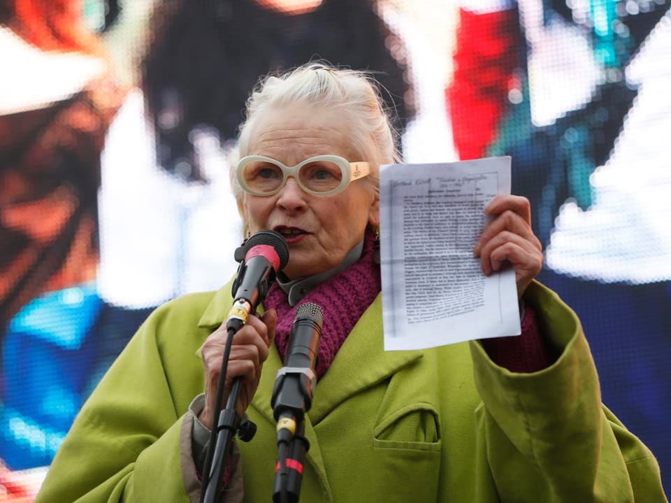 Vivienne Westwood hinter einem Mikrofon stehend mit einem Zettel in der Hand.