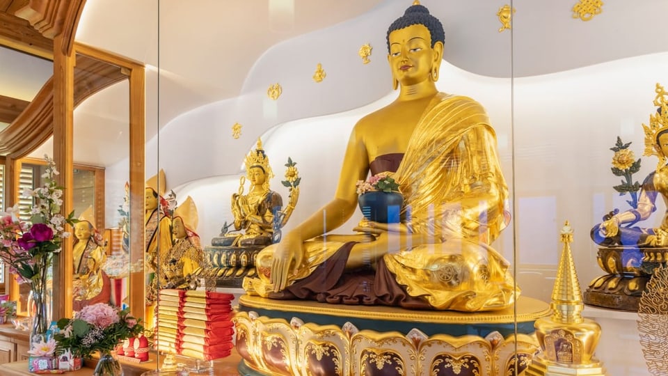 eine goldene Buddhastatue mit vielen Verzierungen