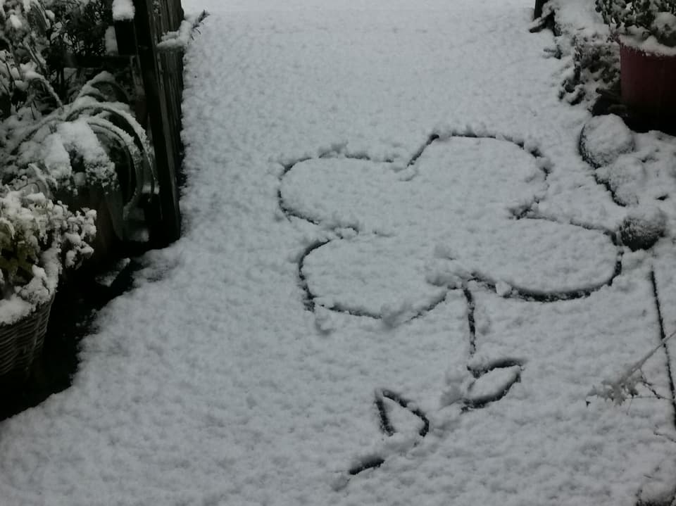 Im Schnee ist von Hand ein Kleeblatt gezeichnet.