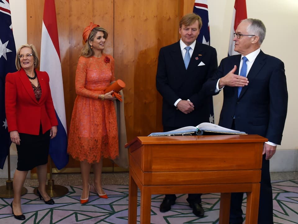 Traditionsbewusst trägt Máxima ein Spitzenkleid in der niederländischen Nationalfarbe. Auch Pumps, Handschuhe und Tasche sind Orange.