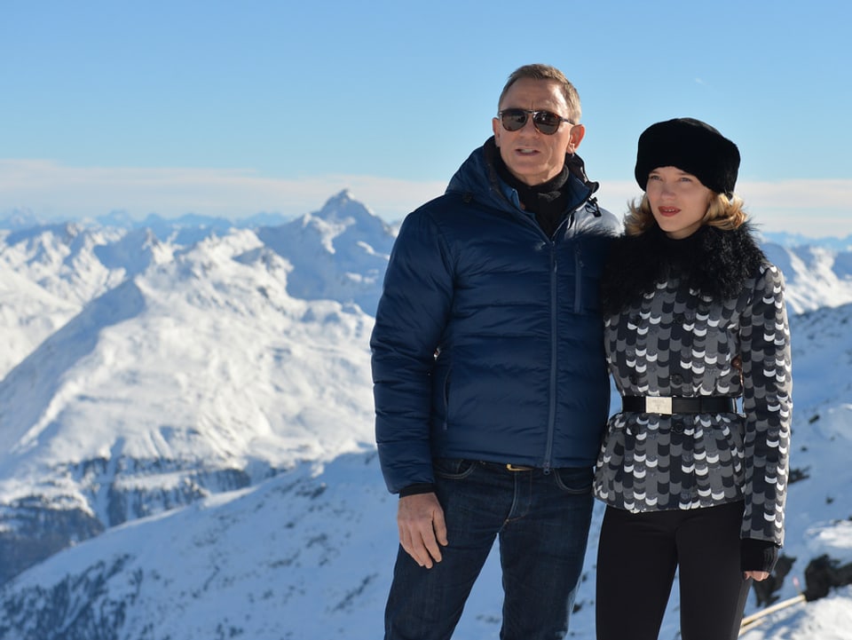 Der Bond-Darsteller und die Frau stehen vor den Bergen.