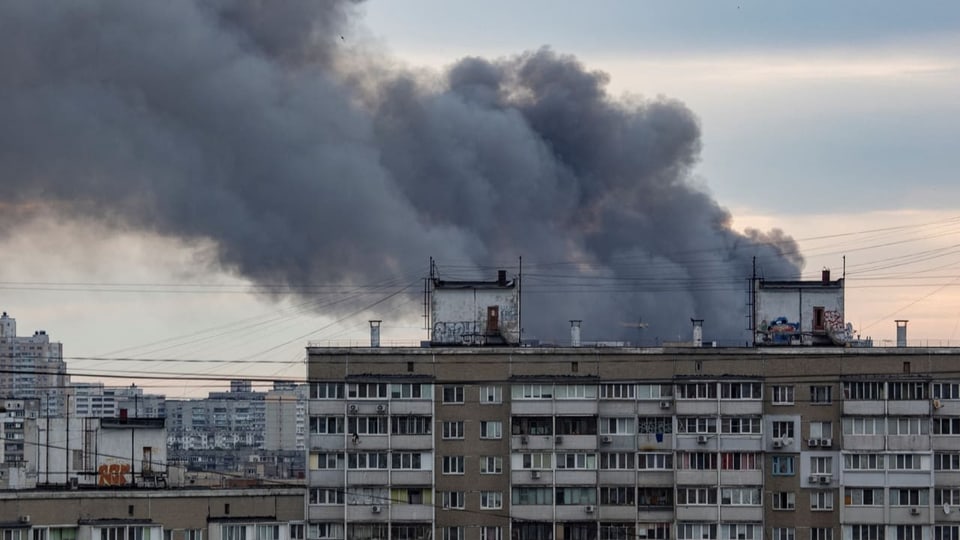 Rauch steigt hinter einem Haus auf, nachdem in Kiew eine Rakete gefallen ist.