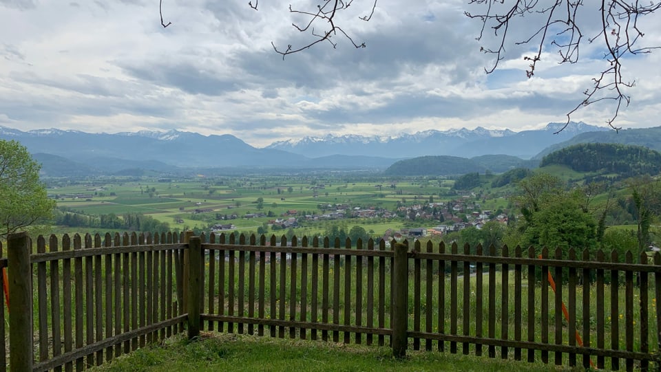 Ausblick aus einem Garten über das St. Galler Rheintal und die Alpen in der Ferne.