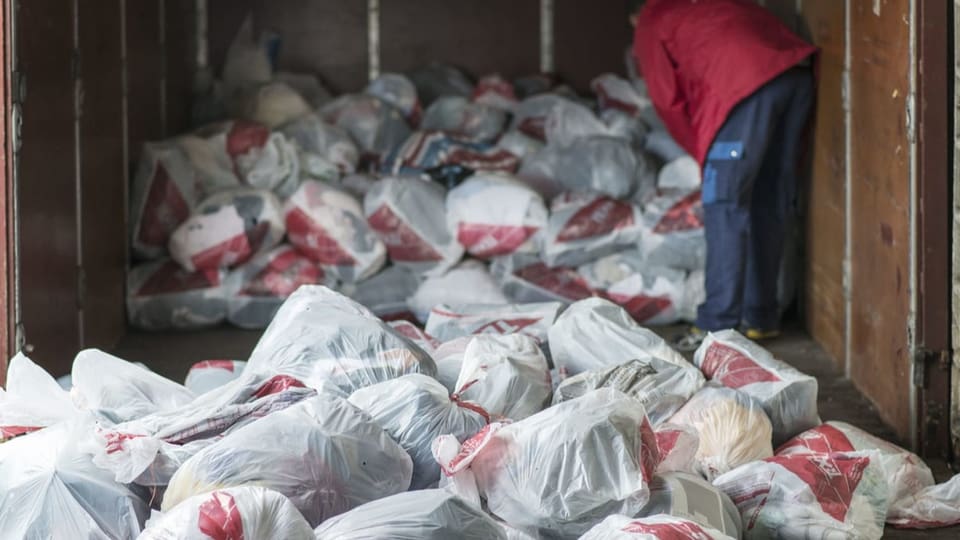 Viele Säcke gefüllt mit Kleidern, liegen in einem Lastwagen. 