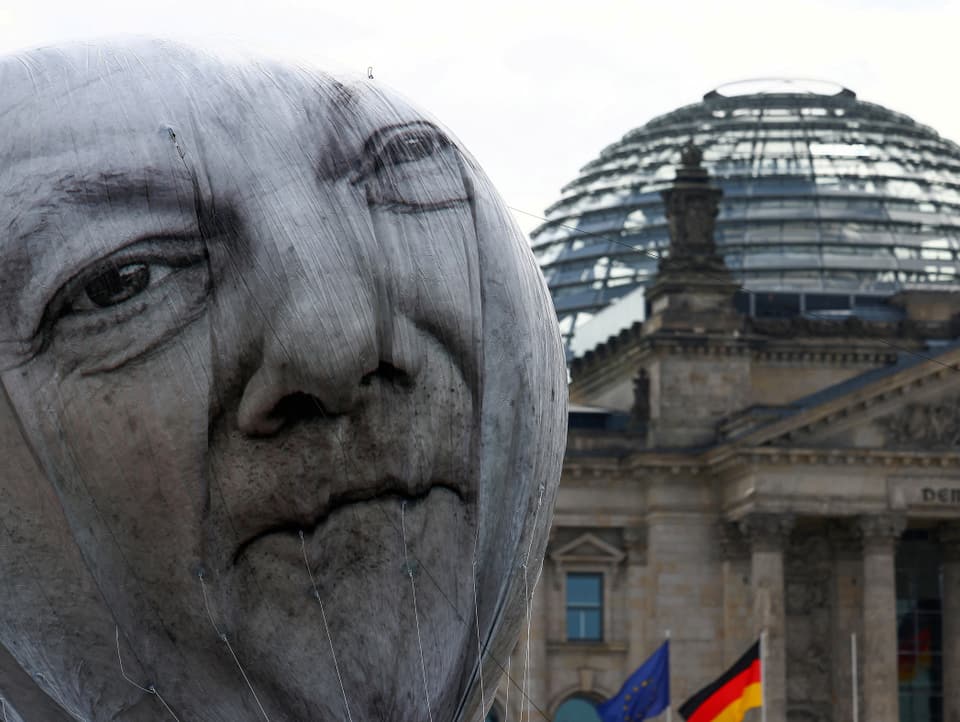 Ein Ballon-Kopf mit dem Gesicht von Olaf Scholz. Im Hintergrund in der Bundestag in Berlin.