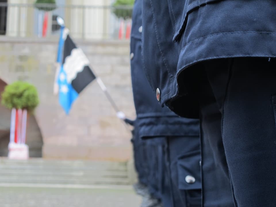 Polizeiuniform mit Fahne im Hintergrund