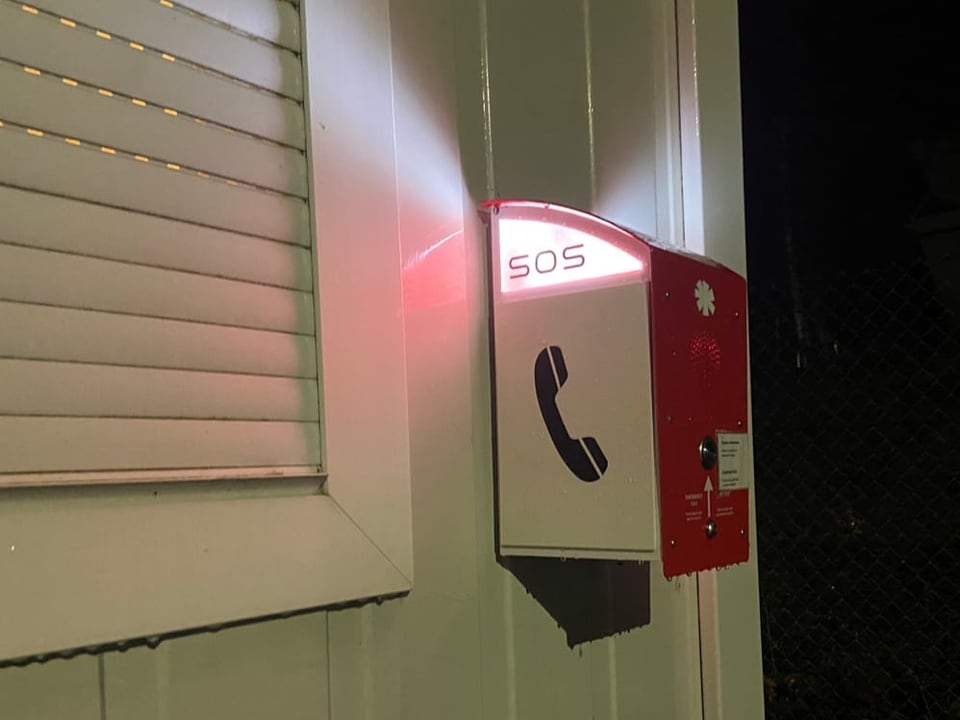 Roter SOS-Kasten an Container-Gebäude