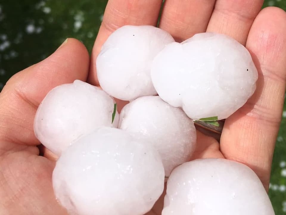 Pingpong-Ball grosse Hagelkörner in einer Hand