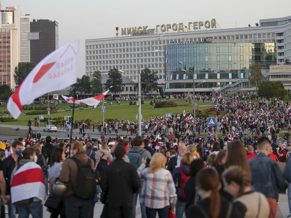 Tausende Demonstrierende schwenken Belarus-Fahnen und versammeln sich auf einem Platz.
