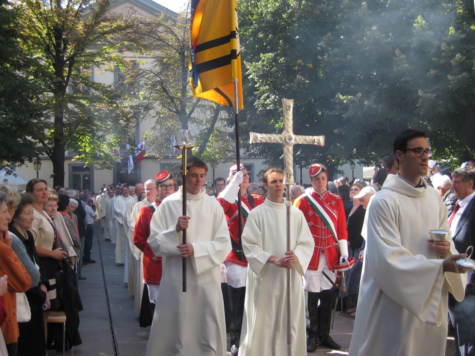 Priester mit Kreuzen und Fahne