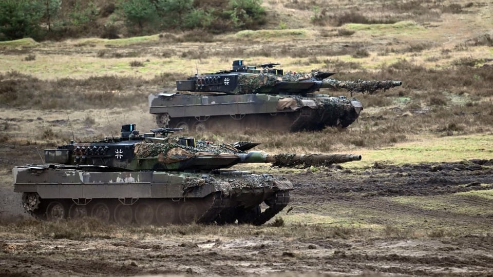 Zwei Leopard 2A6 des Panzerbataillon 203 der Bundeswehr fahren über einen Truppenübungsplatz.
