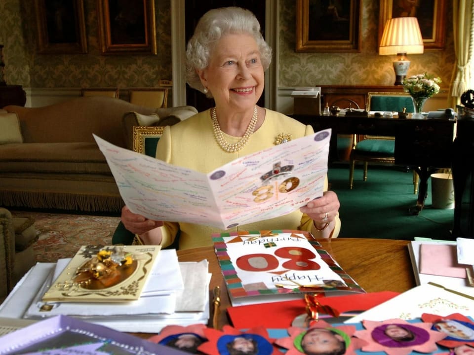 Queen Elizabeth liest eine Glückwunschkarte.