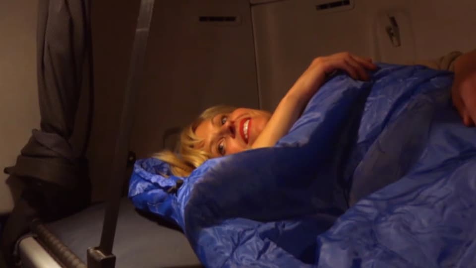Sabine Dahinden in einem Schlafsack in einem Bett in einem Lastwagen