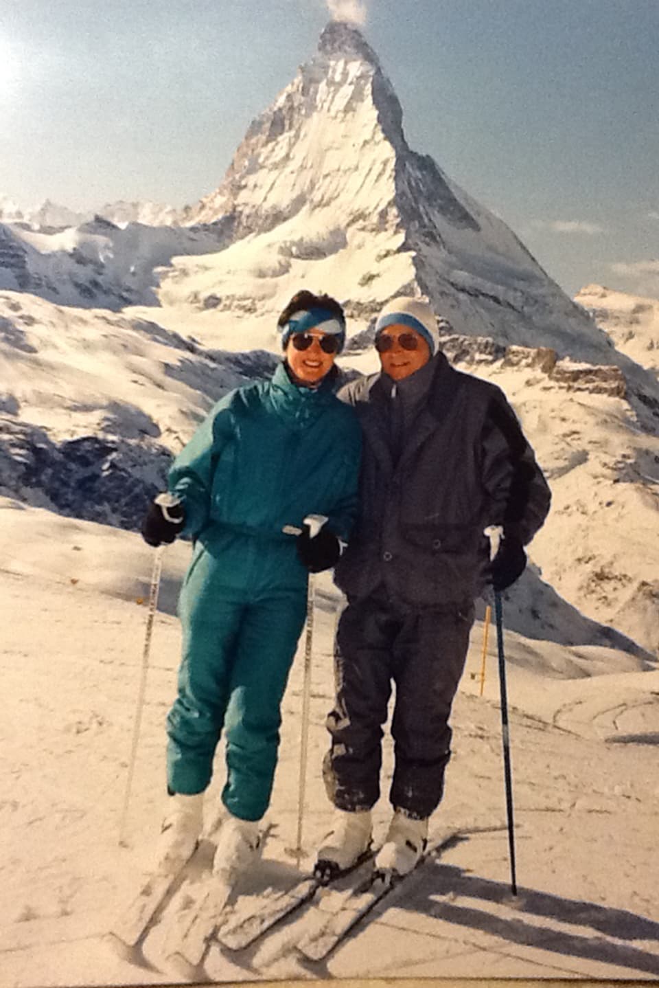 Ein Paar auf Skis. Hinten steht das Matterhorn.