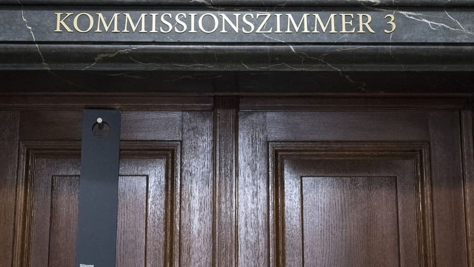 Eine Holztür mit der Aufschrift «Kommissionszimmer 3» ist abgebildet.