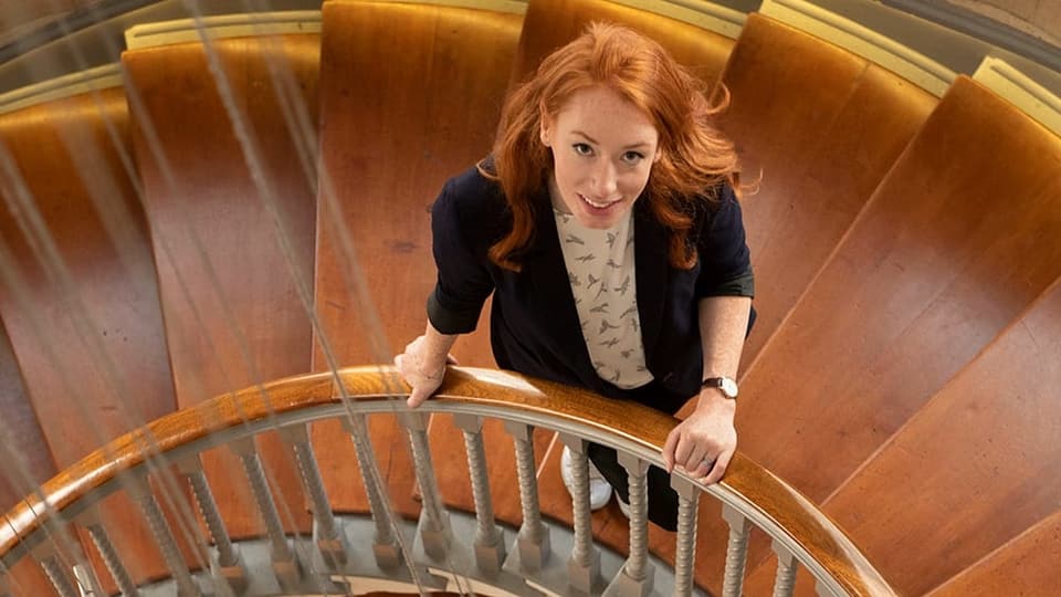 Von den antiken Ursprüngen bis zur Quantenphysik der Gegenwart: Professorin und Autorin Dr. Hannah Fry vor einer Wandtafel mit mathematischen Formeln.