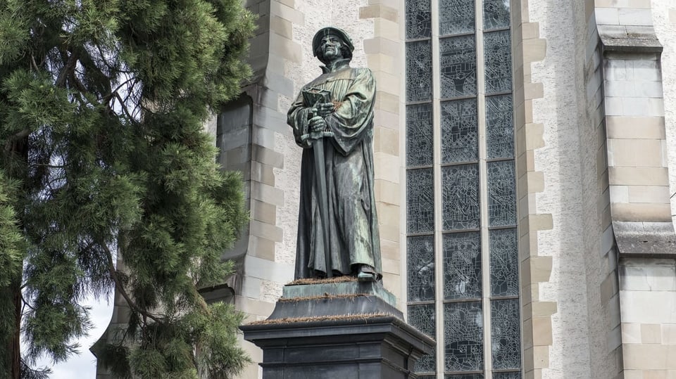 Eine Statue von Zwingli vor einer Kirche