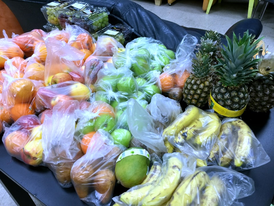 Früchte in Plastiksäcken auf dem Tisch.