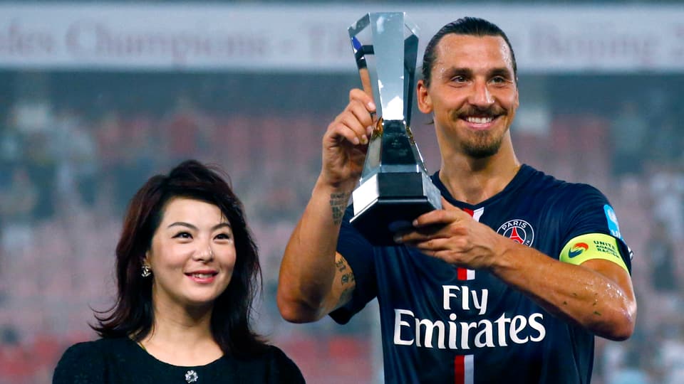 Zlatan Ibrahimovic präsentiert in Peking die französische Supercup-Trophäe.