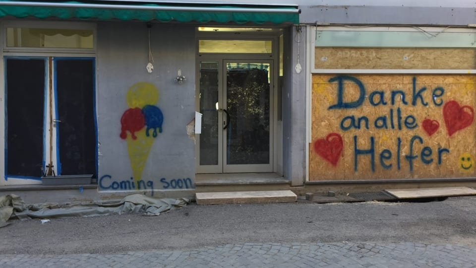 An der Fassade des heruntergekommenen Hauses steht an einer mobilen Holzwand: «Danke an alle Helfer» (mit Herzen drauf).