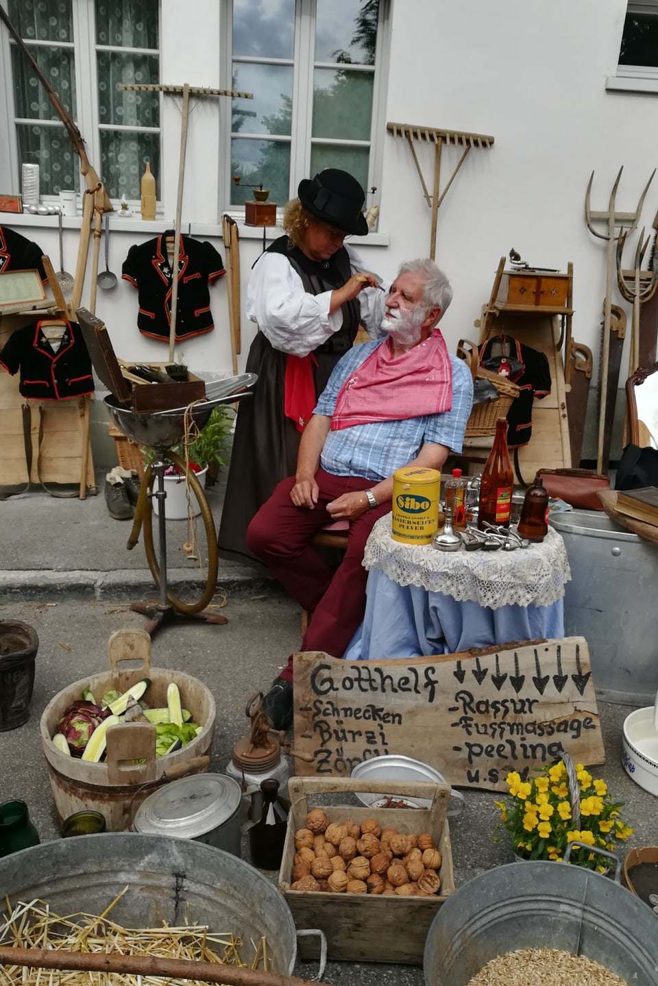 Frau rasiert einem Mann nach alter Tradition den Bart
