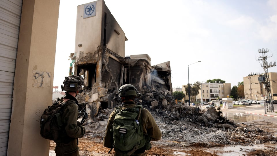 Soldaten vor zerstörtem Gebäude.