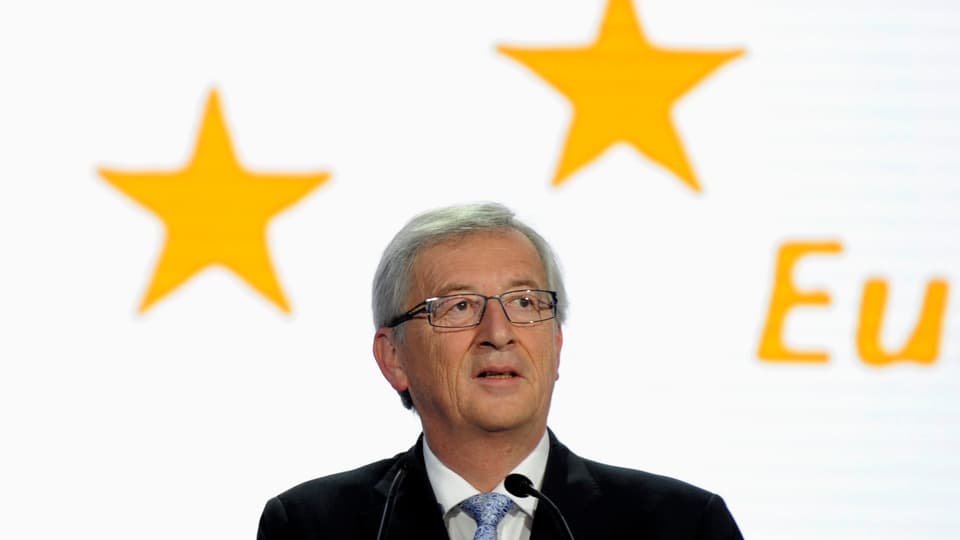 Porträt Jean-Claude Juncker. Im Hintergrund sind EU-Sterne zu sehen.