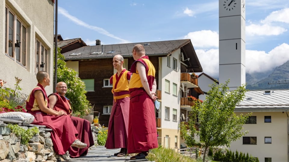 Eine Nonne und drei Mönche unterhalten sich draussen