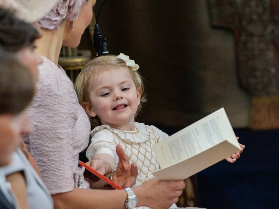 Prinzessin Estelle lächelnd neben ihrer Mutter Victoria sitzend.