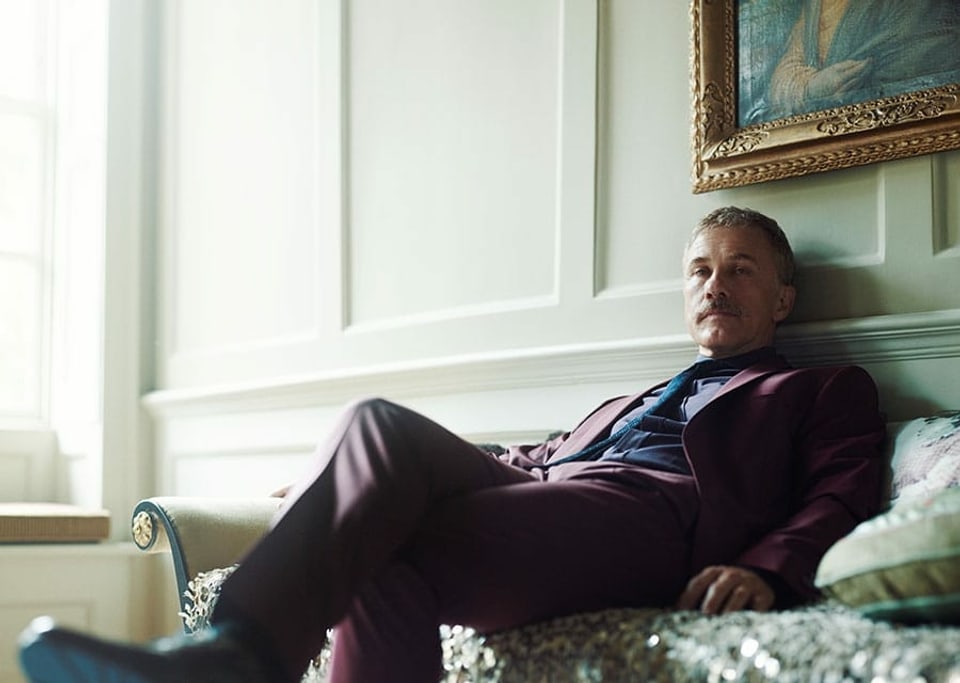 Schauspieler Christoph Waltz sitzt angelehnt auf einem Sofa