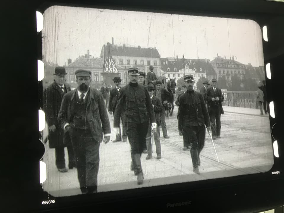 Ausschnitt aus dem Film, ein paar Männer laufen über die Mittlere Brücke. 