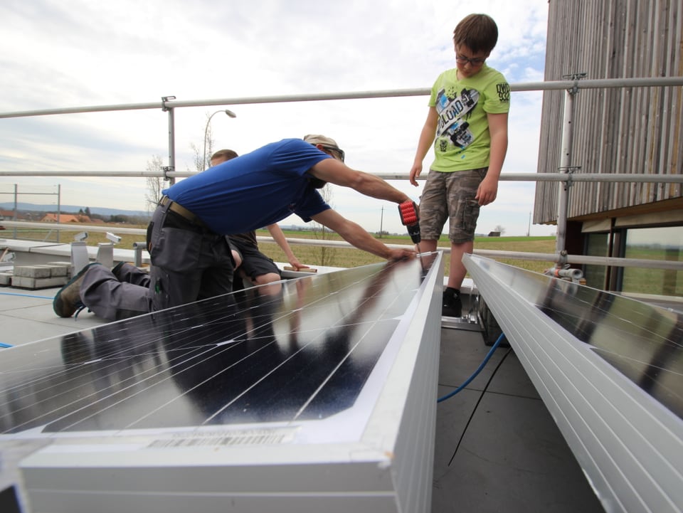 Fachmänner helfen den Sekschülern beim Bau der Solaranlage.