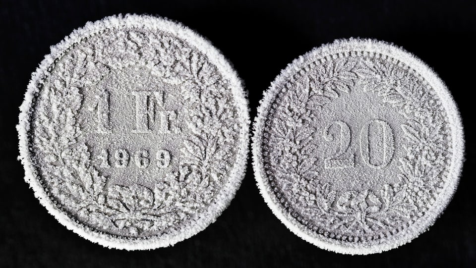 Zwei Münzen: 1 Fr. und 20 Rp., mit Frost darauf