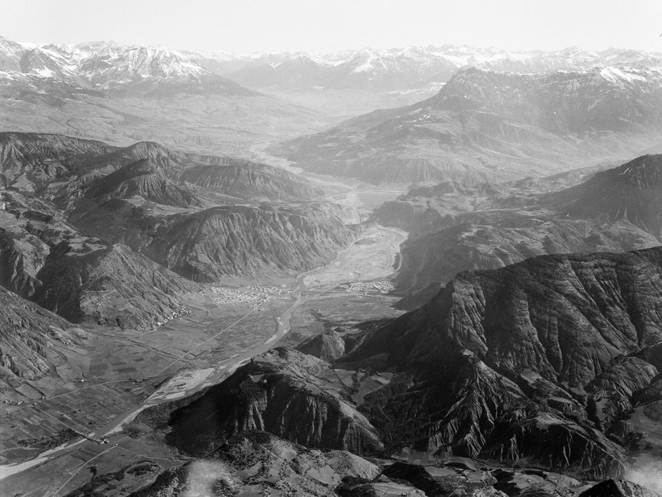 Ein Tal und mehrere Bergketten von oben fotografiert.