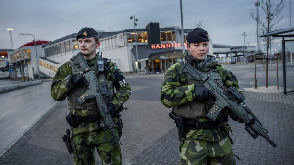 Zwei schwedische Soldaten mit Hand an der Waffe patrouillieren in Gotland