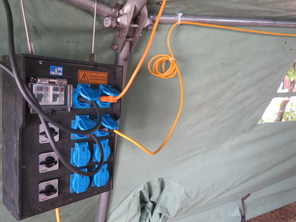 Stromanschluss mit Kabeln in Zelt. 