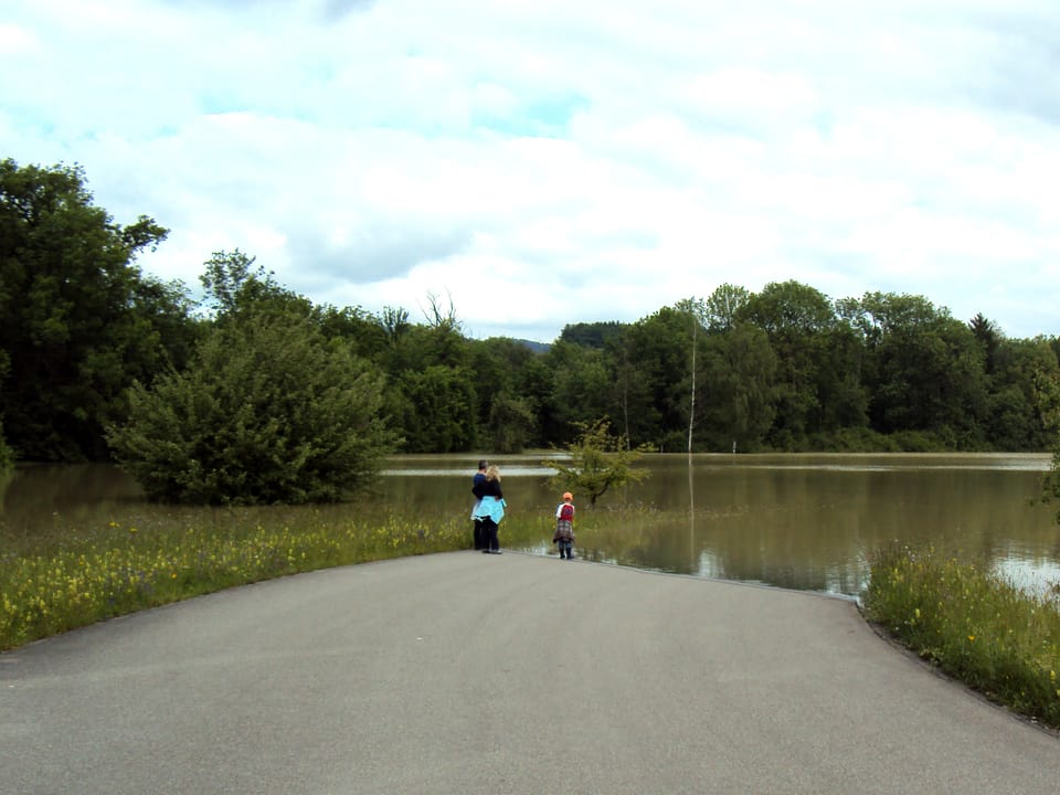 Menschen stehen vor einem See