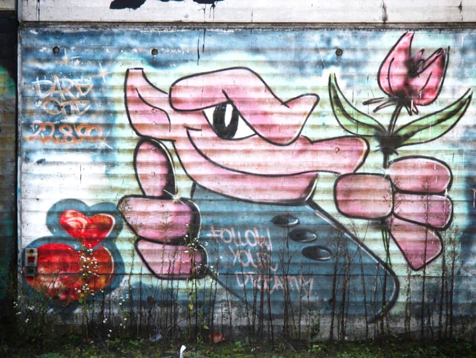 Ein Graffiti, das ein rosa Männchen zeigt.