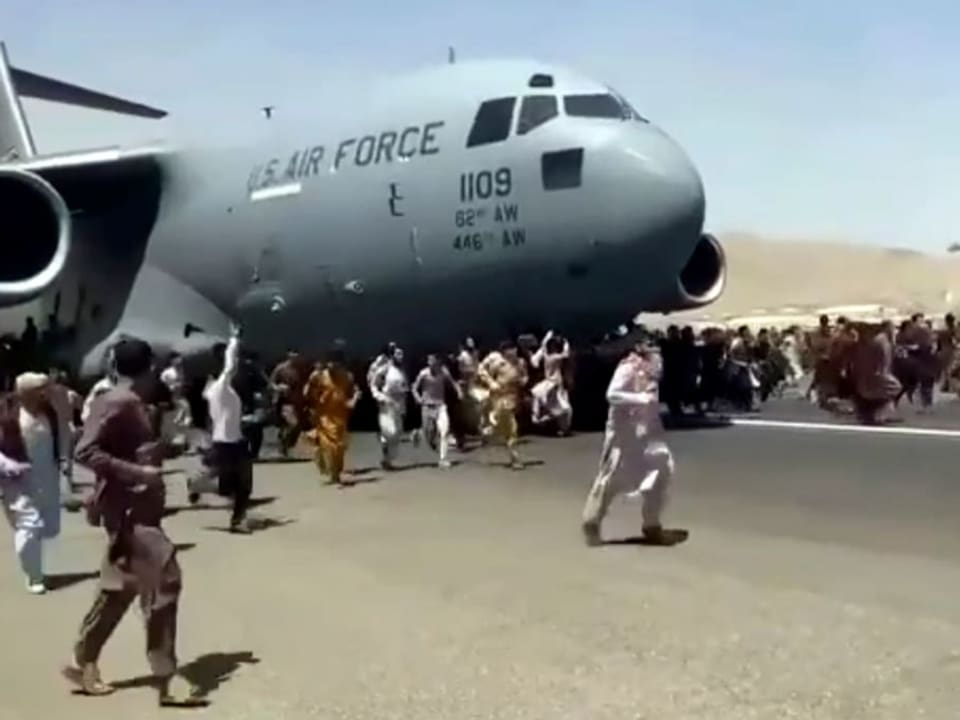 Menschen rennen neben Flugzeug her