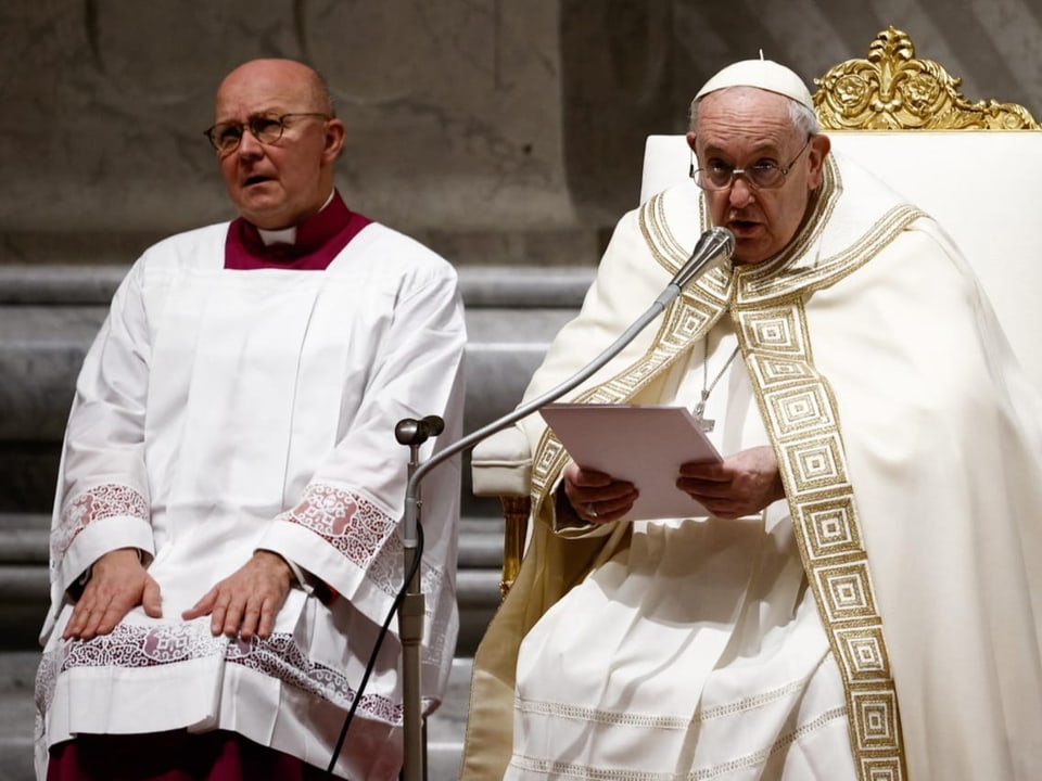 Papst Franziskus spricht in ein Mikrofon.