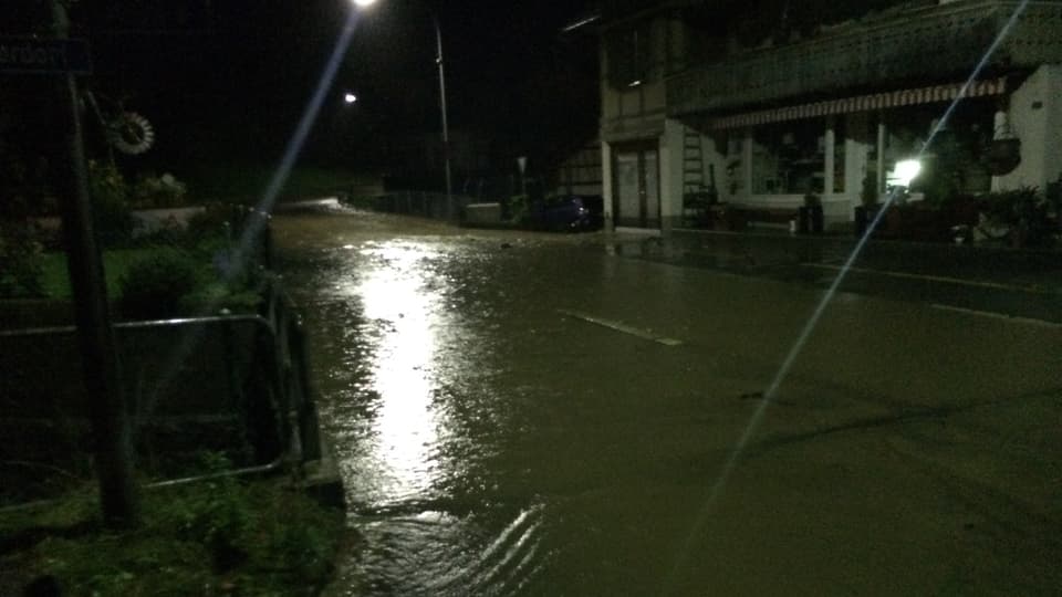 Überflutete Strasse im nächtlichen Wattenwil.