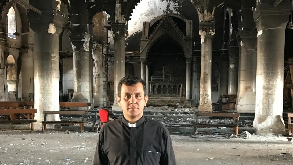 Pater Ammar Yako 2017 in der vom IS zerstörten Al Tahira Kirche.