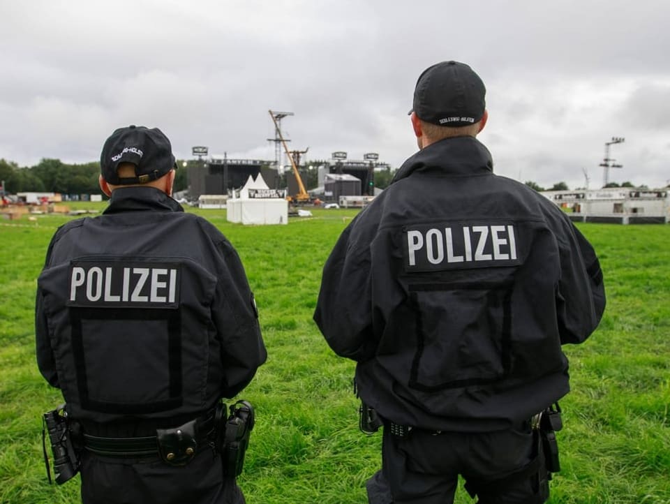 Zwei Polizisten auf dem Festivalgelände von hinten fotografiert