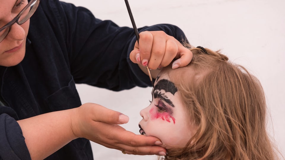 Die Gesichter der Kinder werden zum Kunstwerk geschminkt.