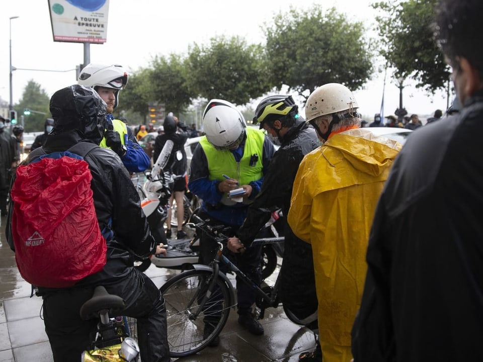 Polizisten verteilen an der Velodemo in Genf eine Busse an einen Velofahrer.