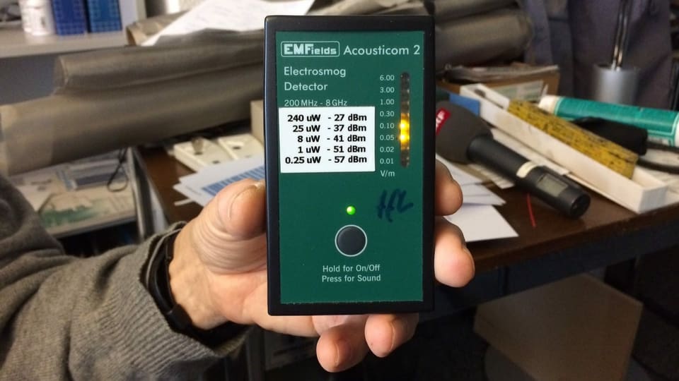 Hand hält Gerät mit grünem Display.